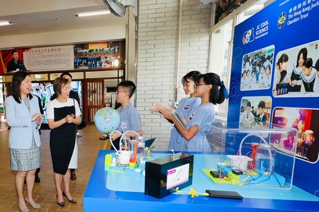 試行夥伴學校學生向嘉賓（左一：教育局常任秘書長陳穎韶、左二：香港賽馬會董事龔楊恩慈）分享實踐經驗及展示成果