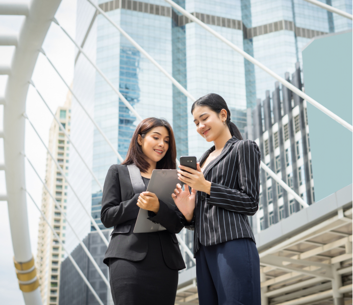 two-business-woman-standing-using-smartphone-discussing-front-office-business-working-concept